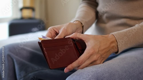 Close up view of a female traveler hands counting Indian rupee cash money while packing a suitcase for a holiday trip. Preparing money and luggage for vacation. Concept of travel expenses in India.