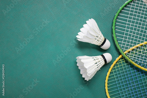 Badminton racket and white shuttlecock on green badminton court