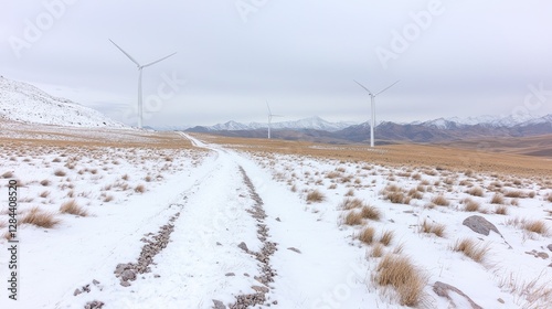 Snowy landscape with wind turbines, mountain path. Possible use stock photo for nature, alternative energy, or travel imagery photo