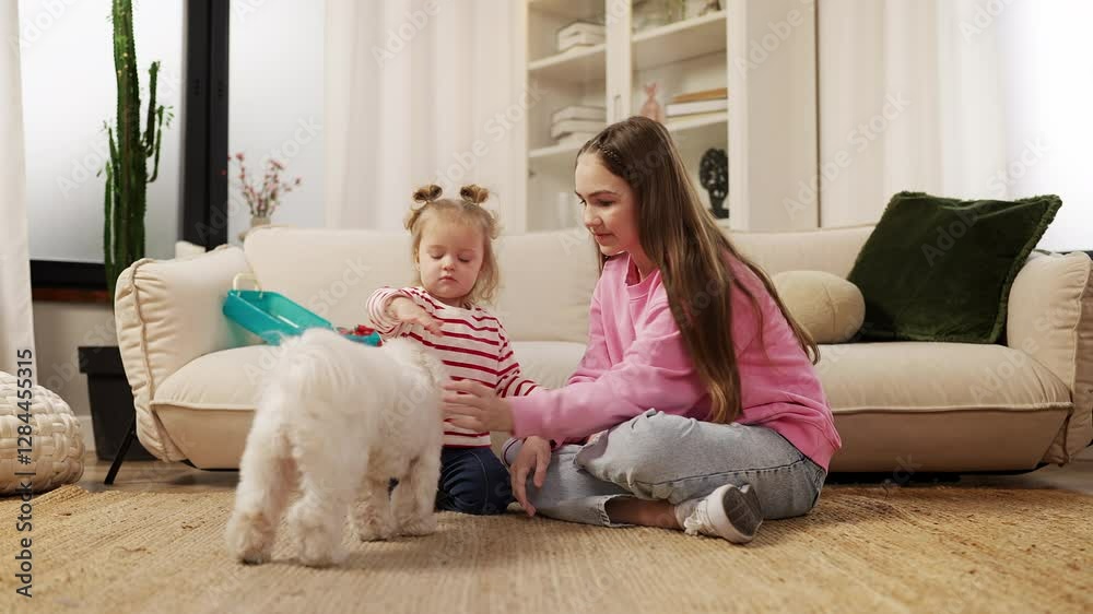 Teen girl and her younger sister give their fluffy dog treats as a fun pastime Teen girl and her younger sister give their fluffy dog treats as a fun pastime