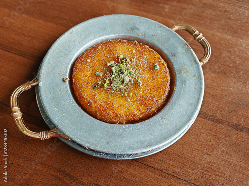 Turkish dessert kunefe, kunafa, kadayif with pistachio powder and cheese hot eaten sweet