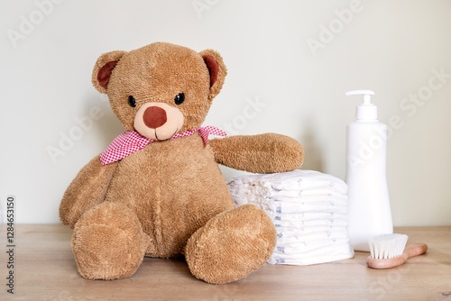 Stack of diapers with toy teddy bear on table.Newborn nappies concept