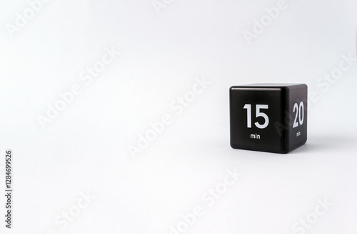 Black cube timer with 15 minutes sign on white background. Minimal interval time concept. Copy space, selective focus