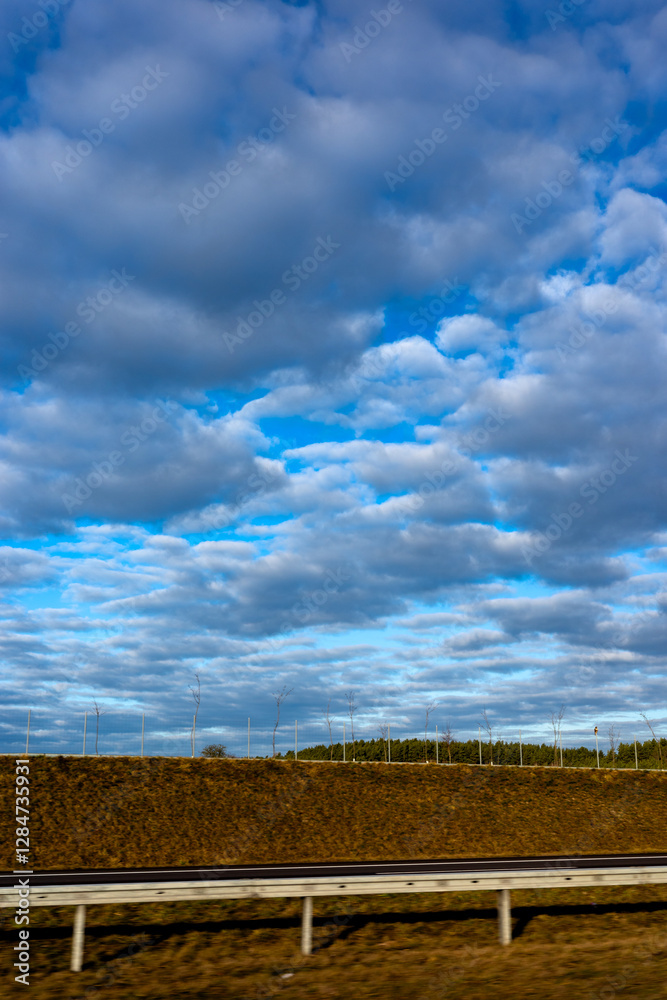 Blue sky and delicate clouds over the highway. The photo was taken on a sunny day.