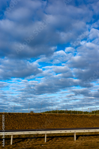 Obraz na płótnie Blue sky and delicate clouds over the highway. The photo was taken on a sunny day. w salonie