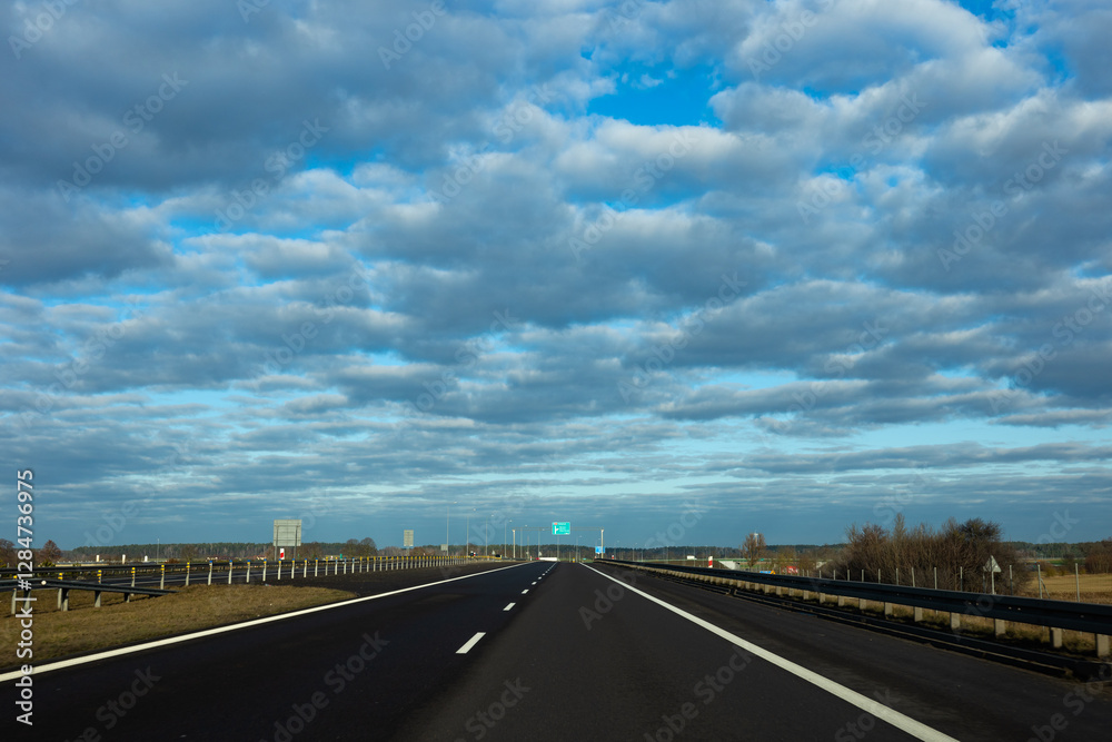 Blue sky and delicate clouds over the highway. The photo was taken on a sunny day.