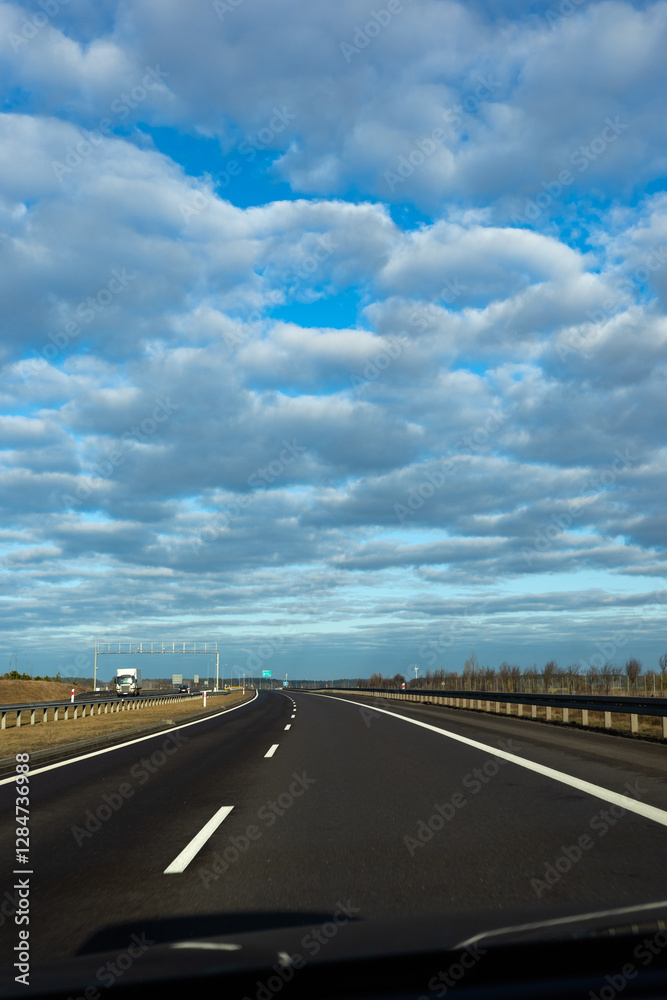 Blue sky and delicate clouds over the highway. The photo was taken on a sunny day.