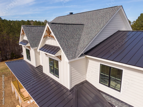Sunny Daytime Drone Images of a Custom Home in the Final Stages of Construction. It Features a Roof With Architectural Asphalt Shingles and Standing Seam Accents. 
