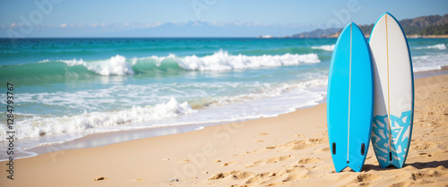 Surfboards on a sandy beach with gentle waves under a clear blue sky conveying a relaxed, sunny mood and representing summer sports activities