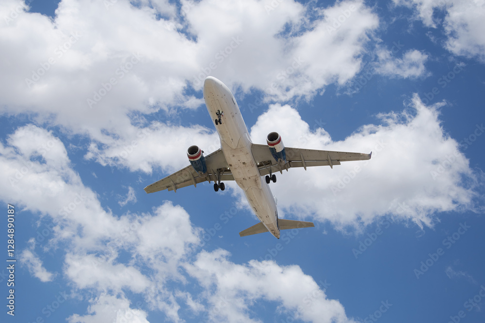 Naklejka premium A plane soaring through the sky, symbolizing a journey of hope and new possibilities, with a clear blue backdrop.