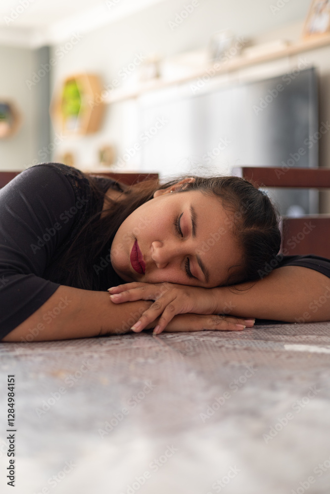 A homemaker asleep at the dining table, resting her head on the surface, ideal for content about exhaustion, home life, and relaxation. A homemaker asleep at the dining table, resting her head on the surface, ideal for content about exhaustion, home life, and relaxation.
