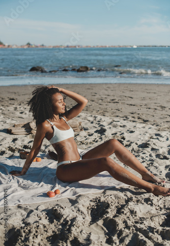 Athletic young woman in a bikini sunbathing and relaxing at the beach