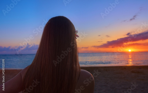 Island Girl on beach looking at the sunset.