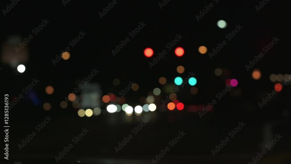 Blurred City Lights at Night with Colorful Bokeh Defocused night scene of city street with colorful bokeh lights from traffic signals, streetlights car headlights, creating vibrant urban atmosphere