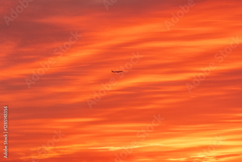 Aerial photo of another aircraft Silhouette against the Sunset sky clouds as it take off  photo