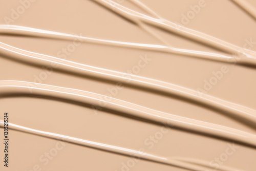 Makeup foundation cream texture background. Beige concealer, BB cream smeared