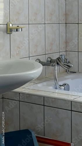 white tiled bathroom with bathtub and washbasin