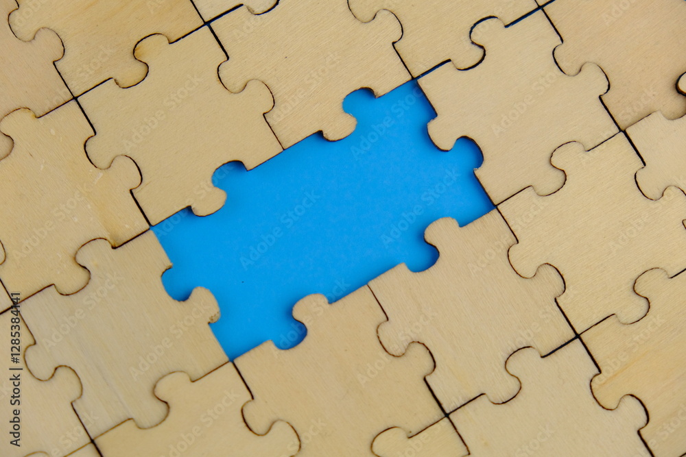white jigsaw puzzle with missing puzzle for a text template. Above photo of isolated on the blue background white jigsaw puzzle with missing puzzle for a text template. Above photo of isolated on the blue background