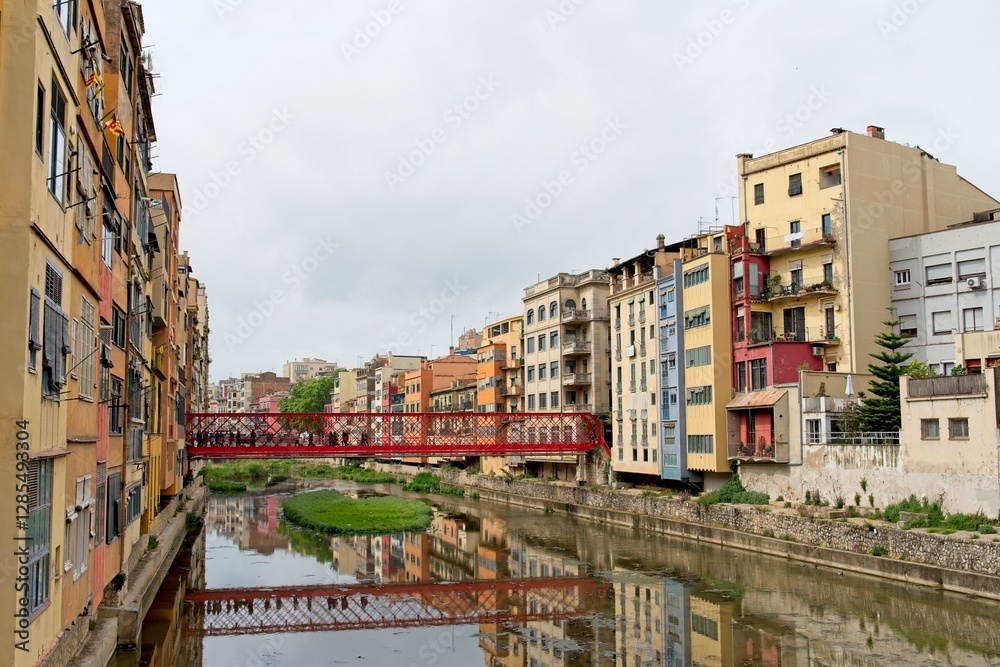 Fototapeta premium Girona Spain - 27 April 2024 - The Iron Bridge (Pont de les Peixateries Velles or Pont de Eiffel) over River Onyar in Girona