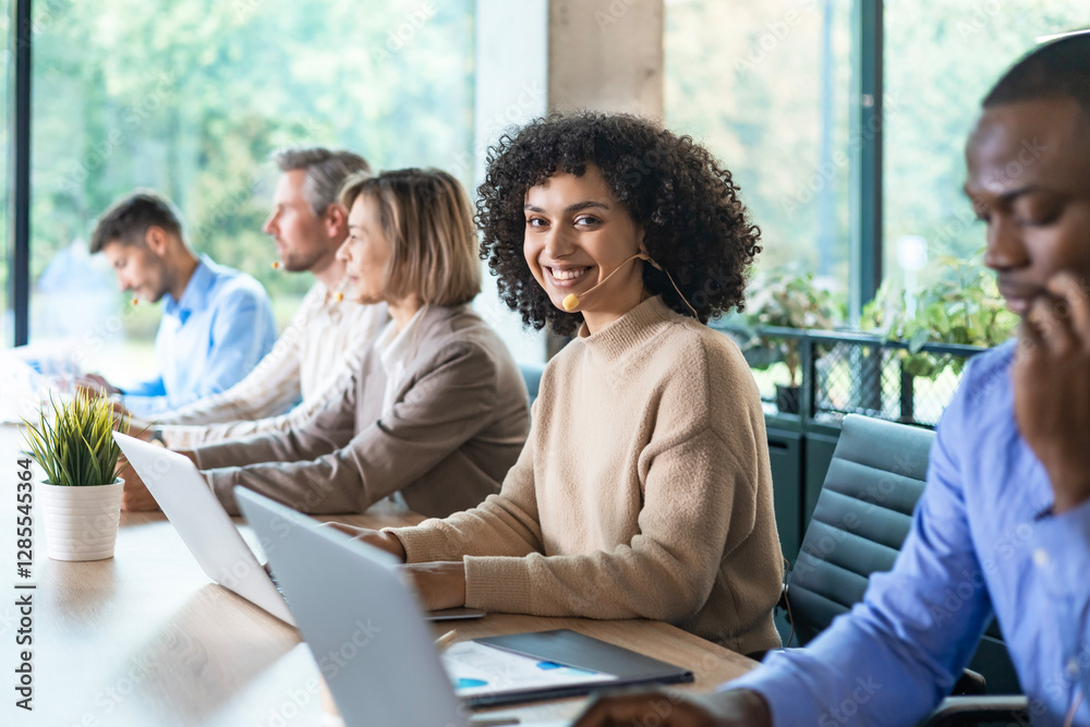 Portrait of call center worker accompanied by her team. Smiling customer support operator at work. Portrait of call center worker accompanied by her team. Smiling customer support operator at work.