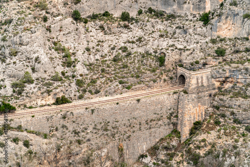 Mountainous landscape with a railway track and tunnels photo
