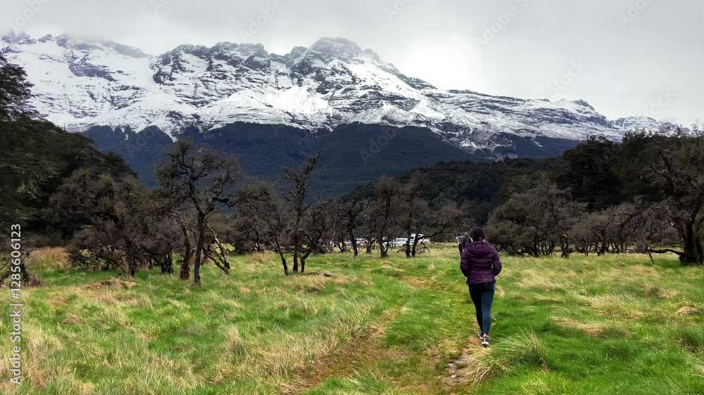 Girl walks grass field towards scenic Icy mountains Chinaman's Bluff Girl walks grass field towards scenic Icy mountains Chinaman's Bluff