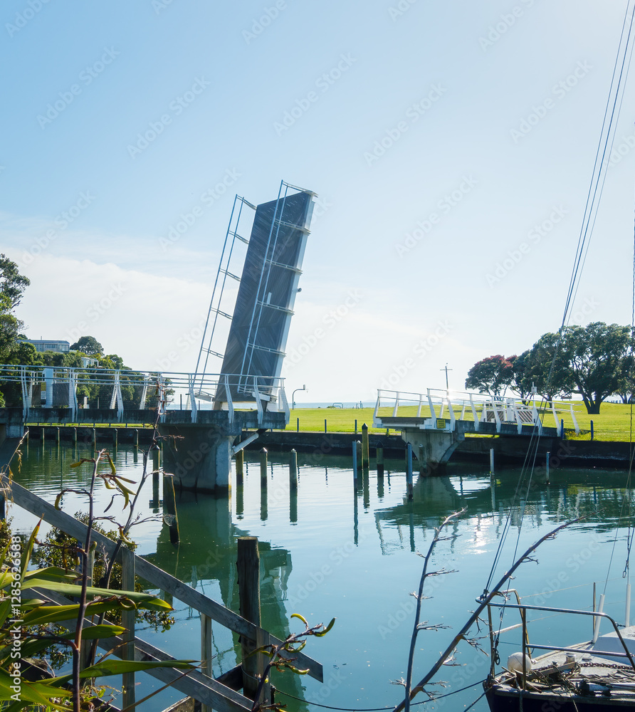 Milford marina footbridge lifting span raised to let boats crossing. Auckland.