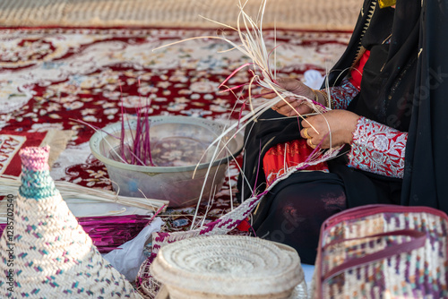 Close-up of hands weaving a basket from reeds, showcasing traditional craftsmanship and cultural heritage