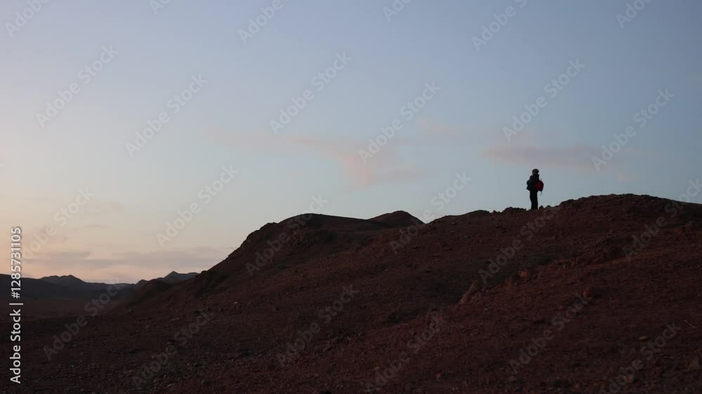 Backpacker contemplating marsa alam desert at dusk