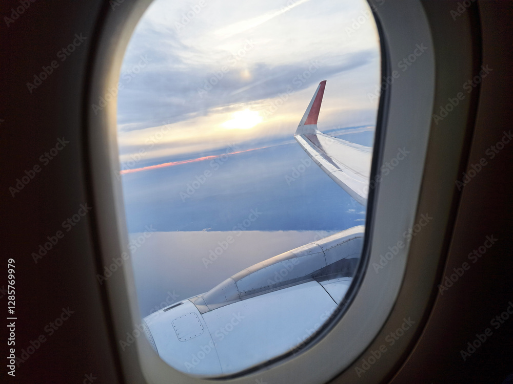 Sunset view from an airplane window with breathtaking clouds. Golden sunlight reflecting on the cloudscape at high altitude. Serene and dreamy aerial view above the sky. Peaceful flight atmosphere. Sunset view from an airplane window with breathtaking clouds. Golden sunlight reflecting on the cloudscape at high altitude. Serene and dreamy aerial view above the sky. Peaceful flight atmosphere.