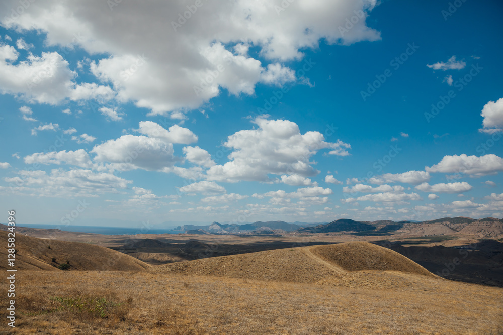 Hills with dry yellow grass and blue sky with clouds Hills with dry yellow grass and blue sky with clouds
