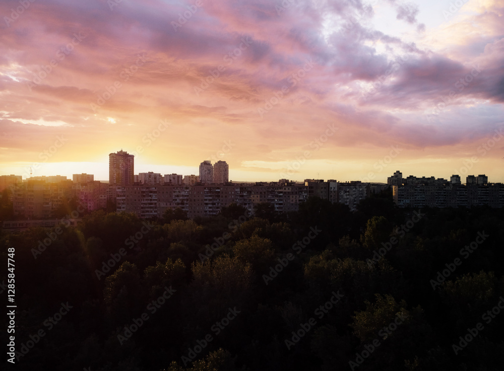Sunset Silhouetting Urban Residential Buildings with Atmospheric Sky and Forest.. Sunset Silhouetting Urban Residential Buildings with Atmospheric Sky and Forest..