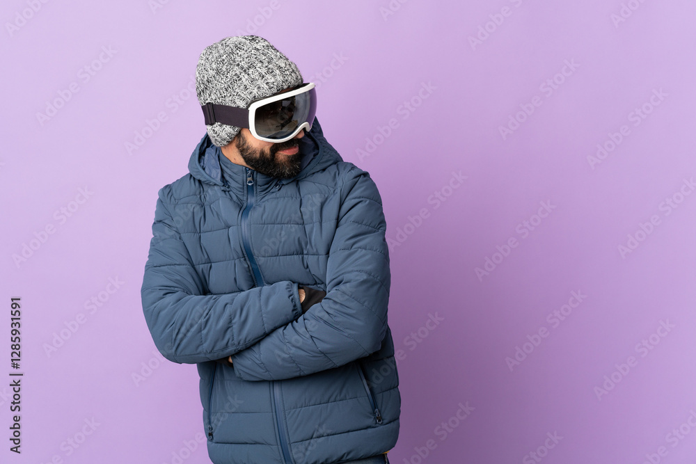 Skier man with snowboarding glasses over isolated purple background