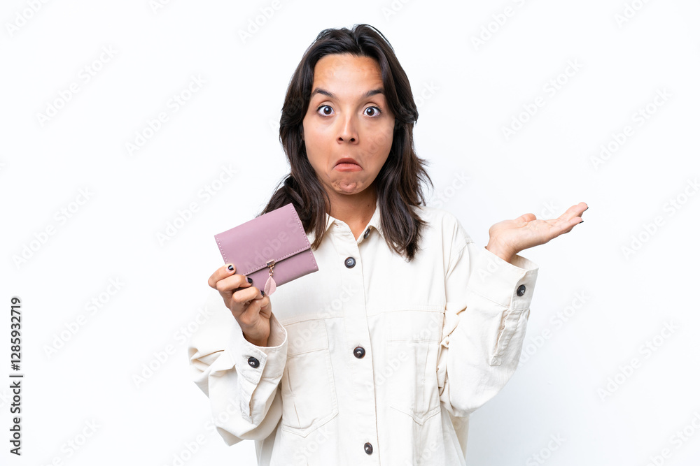 Young hispanic woman holding wallet isolated on white background having doubts while raising hands Young hispanic woman holding wallet isolated on white background having doubts while raising hands