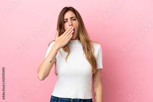 Caucasian woman isolated on pink background yawning and covering wide open mouth with hand