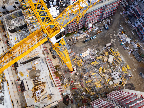 Construction site with tower cranes and building materials. Aerial view of an apartment complex under construction.