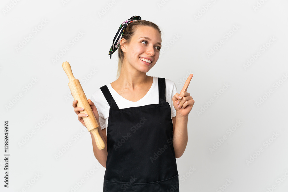Young woman holding a rolling pin isolated on white background pointing up a great idea Young woman holding a rolling pin isolated on white background pointing up a great idea