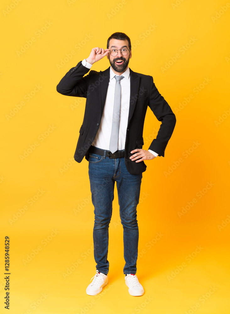 Φωτογραφία Full-length shot of business man over isolated yellow background with glasses an