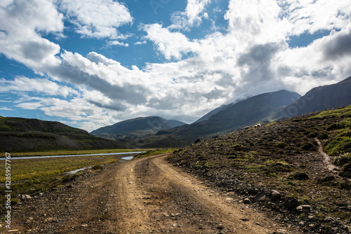 Dirt road in the Scottish Highlands on a sunny summer day.