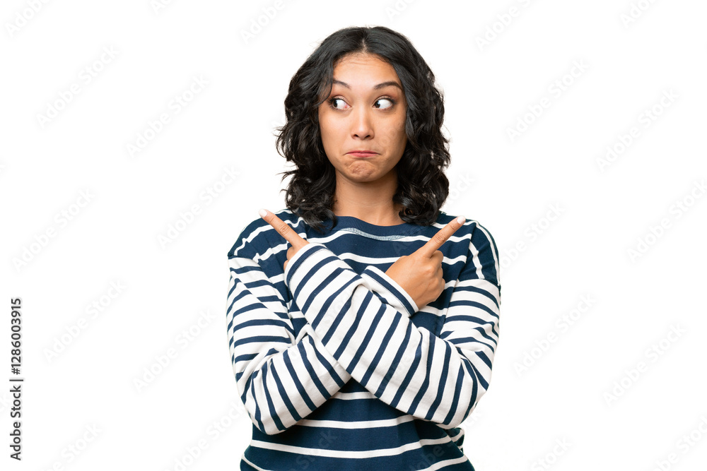 Fototapeta premium Young Argentinian woman over isolated background pointing to the laterals having doubts