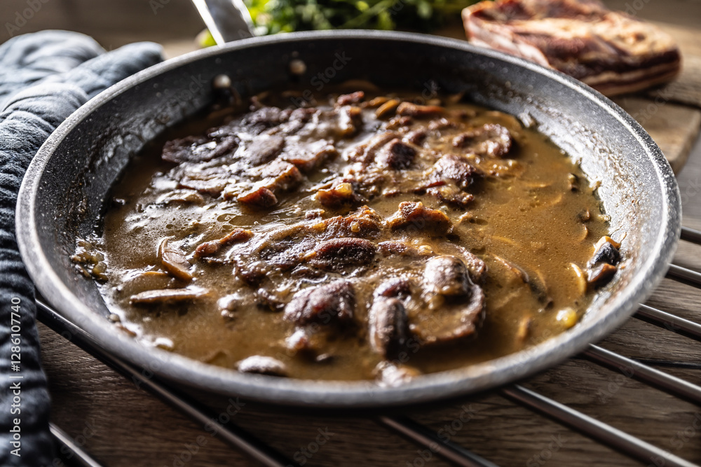 Roasted Pork Neck with Mushroom Sauce in a Ceramic Pan Roasted Pork Neck with Mushroom Sauce in a Ceramic Pan