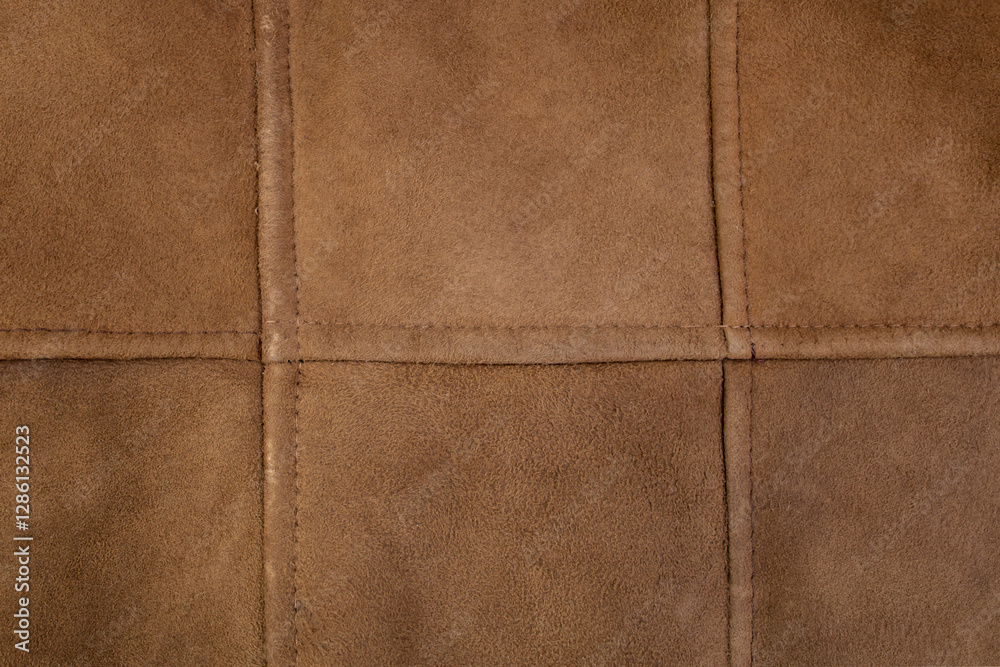 Fototapeta premium Suede genuine leather stitches grid, brown color animal skin for clothes manufacturing , abstract backdrop