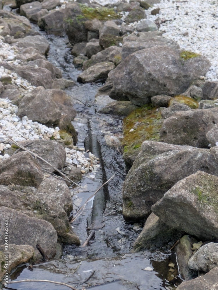 A gentle stone stream with rocks and flowing water A gentle stone stream with rocks and flowing water
