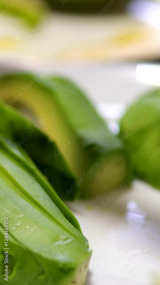 female hand stacks fresh avocado slices. Raw avocado pieces close up. Shot in slow motion with RED camera. female hand stacks fresh avocado slices. Raw avocado pieces close up. Shot in slow motion with RED camera.