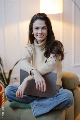 Young woman portrait. Freelancer with laptop on couch.