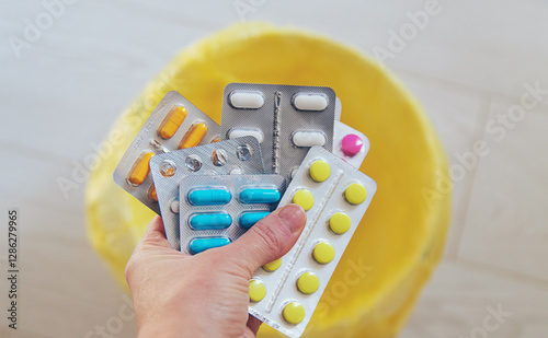 Throwing pills in the trash. Selective focus.