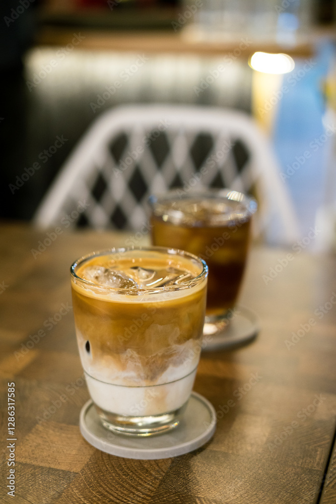 Hot latte & iced tea on cafe table. Layered coffee, cool iced beverage, indoor setting, warm drink, refreshment. Hot latte & iced tea on cafe table. Layered coffee, cool iced beverage, indoor setting, warm drink, refreshment.