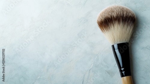 A stunningly designed makeup brush rests on a pastel textured background, showcasing its versatile bristles and appealing to beauty lovers and professional makeup artists alike.