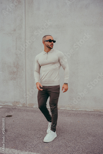 Obraz na płótnie Chico joven tatuado posando con ropa actual en la calle w salonie