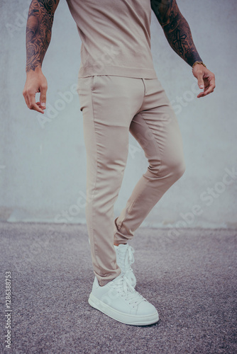 Obraz na płótnie Chico joven tatuado posando con ropa actual en la calle w salonie